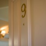 A room door ajar with a brass number 9.