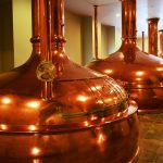 A room with four very large copper brewing stills.