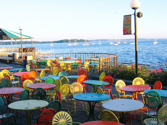 A sunny view of Lake Mendota behind the Memorial Terrace filled with the colorful and iconic "Terrace Chairs".